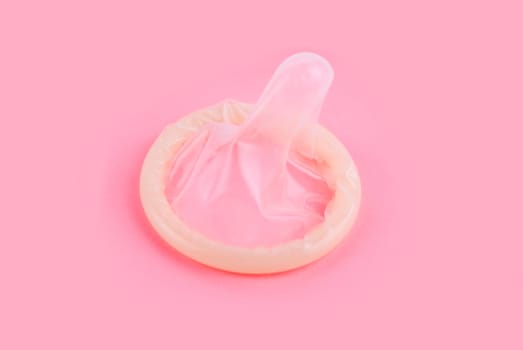 yellow condom on pink background