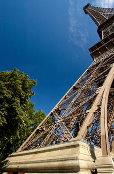 Unusual perspective of the Eiffel Tower, taken with a wide angle lens, with a blue sky background