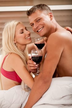 Couple sharing wine in bed