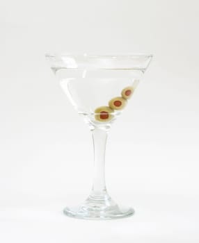 A vodka martini with three fresh olives inside.