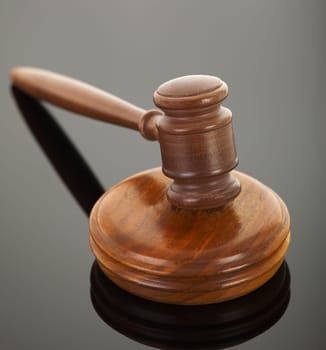 wooden gavel with reflection on black
