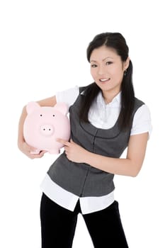 Beautiful Asian businesswoman holding a piggy bank