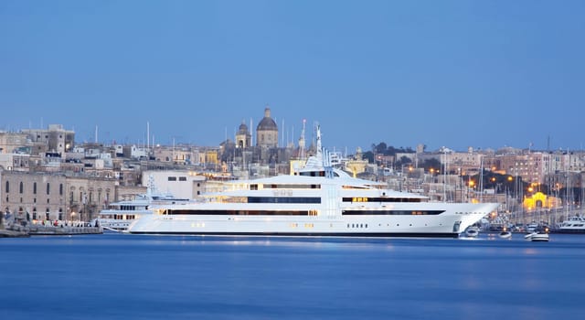 a super yacht berthed in a marina in malta