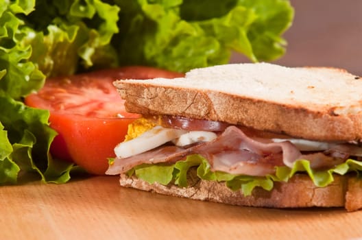 bacon and egg sandwich on wooden board