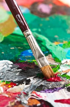 Detail of a paintbrush on an artist's palette