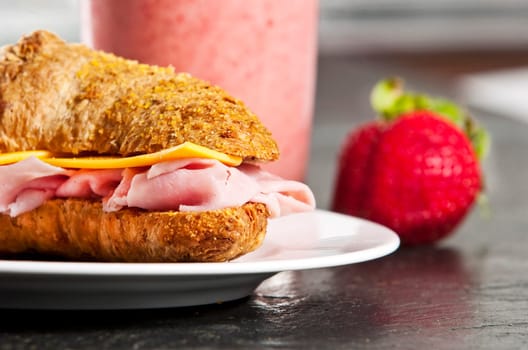 Continental breakfast with croissant and strawberry smoothie