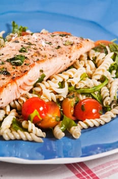 grilled salmon on blue plate with tomato and arugula pasta salad