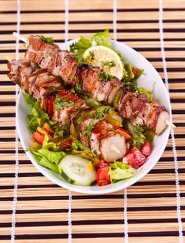 Grilled chicken kebab served with a fresh salad