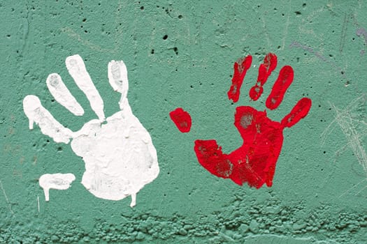 Hand prints with paint on concrete wall