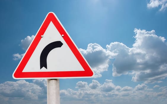 Road turning right traffic sign against bright sky