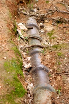 Eroded soil reveals water pipes underneath.