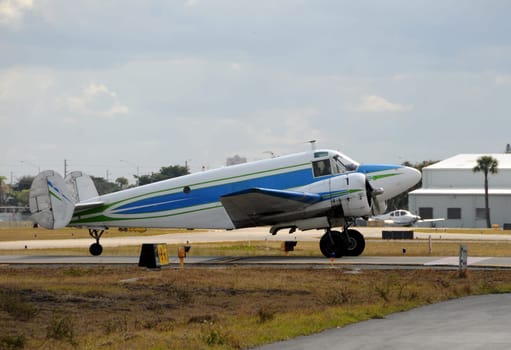 Vintage propeller airplane taxiing on a tarmac