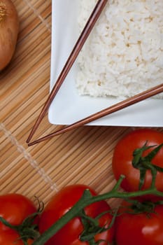 A bowl of perfectly cooked, plain Basmati rice, in an Asian style bowl, with a garnish of Thai Basil
