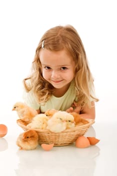 Smiling little girl with a basket full of young chickens - isolated