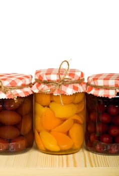Homemade canned fruits in jars on the shelf - isolated