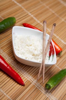 A bowl of perfectly cooked, plain Basmati rice, in an Asian style bowl, with a garnish of Thai Basil