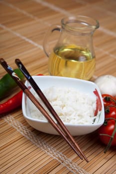 A bowl of perfectly cooked, plain Basmati rice, in an Asian style bowl, with a garnish of Thai Basil