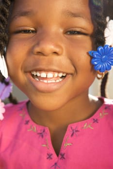 An adorable little african american girl in a pink shirt