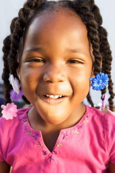 An adorable little african american girl in a pink shirt