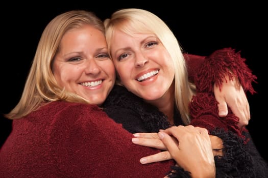 Two Beautiful Smiling Sisters Portrait Isolated on a Black Background.
