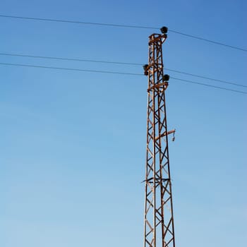Old rusty electical pylon and blue sky