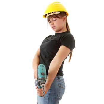 Young woman builder in yellow helmet holding driller