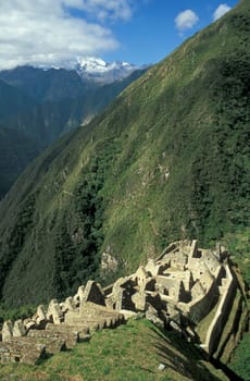 Long abandoned stone buildings of the Inca village of Winay Wayna high in the mountains of Peru