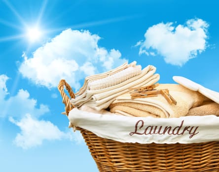 Laundry basket with towels against a blue sky