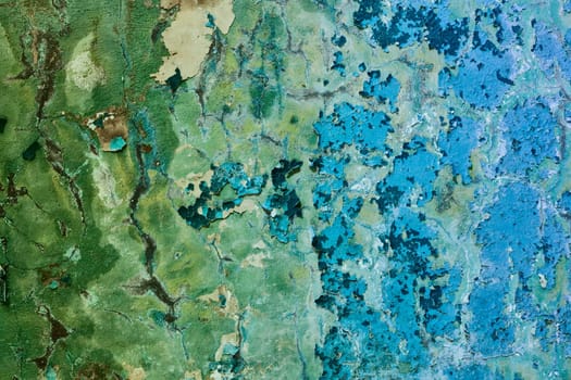 Old painted mangy wall of a building with cracks background