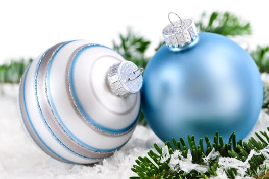 Two Christmas decoration in snow with pine branches