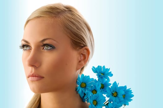 beauty portrait of pretty blond girl with blue daisy
