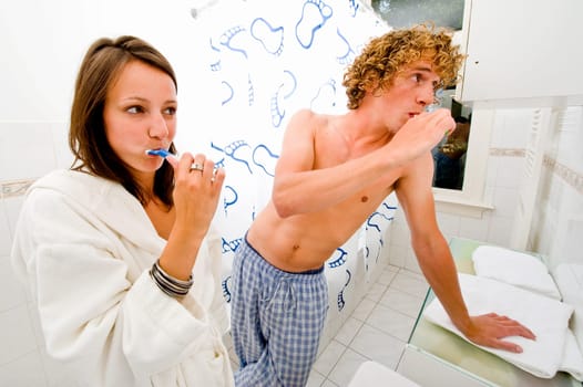 A couple brushing their teeth together in a bathroom