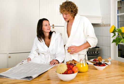Young couple at the breakfast table discussing the events in the paper