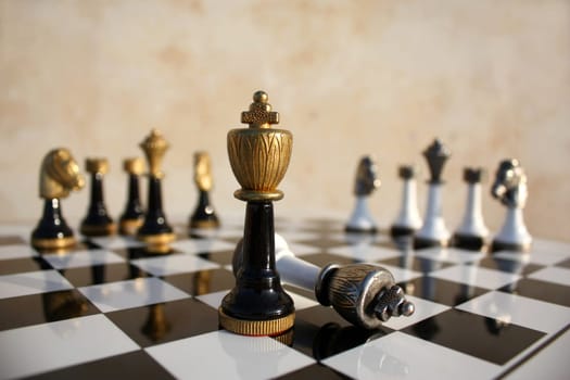 The end of a duel on a chessboard, the dark  wins the light king is fallen
