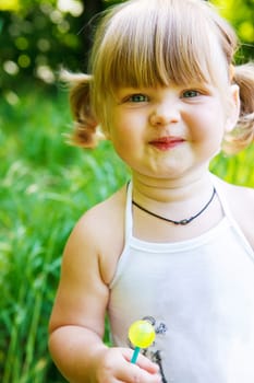 Portrait of a cute toddler holding a lollipop