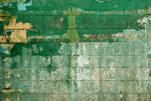 Green surface of the old, semidecayed wall covered with boards