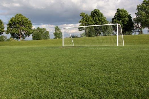 A view of a net on a vacant soccer pitch.