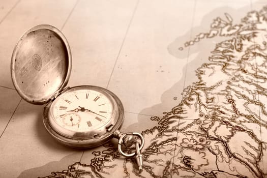 Old silver pocket watch on old map
