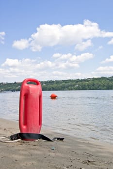 Lifeguard buoy in sand next to river