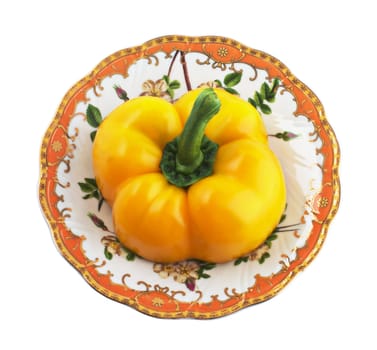 Half of yellow pepper on a patterned saucer