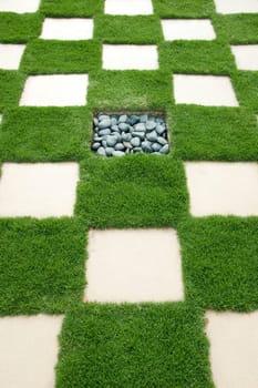 Brick with manicured lawn, with rock in the center.