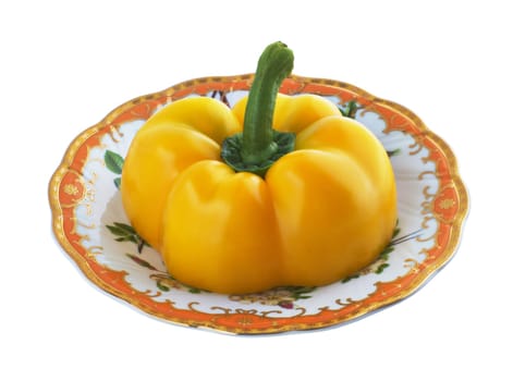 Half of yellow pepper on a patterned saucer