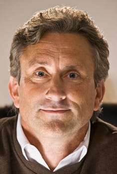 A man is smiling at the camera.  Vertically framed shot.