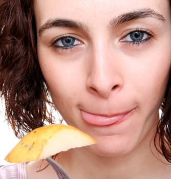 Woman eating tasty pear with forch.
