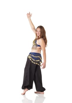 Young Caucasian belly dancing girl in beautiful decorated clothes on white background and reflective floor. Not isolated