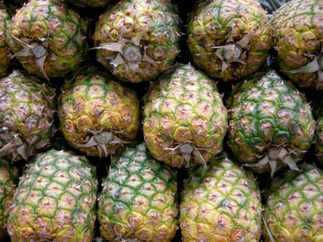 Stock photo of a stack of pineapples in a marketplace