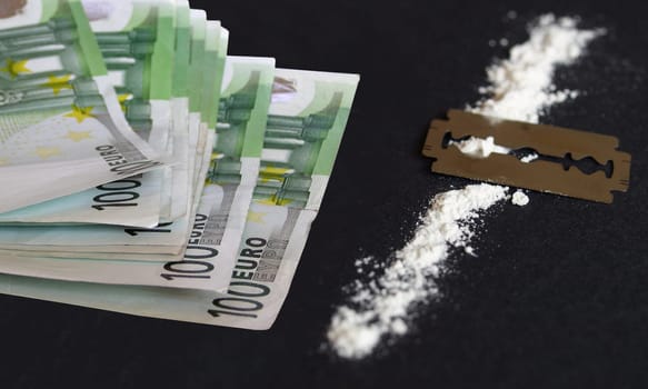 Cocaine, razor blade and money (simulation using wheat flour, no actual drugs used)