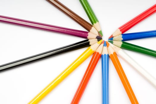 Assortment of coloured pencils with shadow on white background