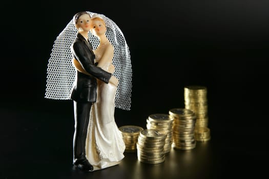 Love and money metaphor, wedding figurine and golden coins