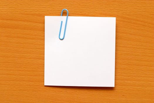 Paper note with a blue clip over the wooden table
